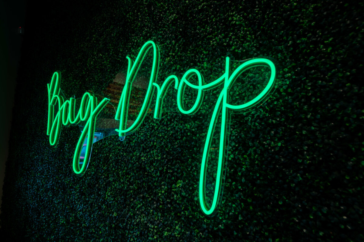 Neon sign reads "Bag Drop"