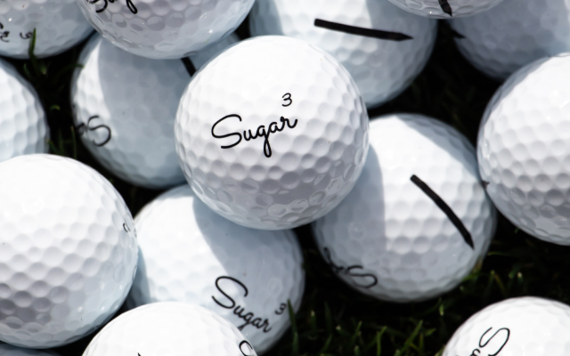 Closeup of several Sugar brand golf balls